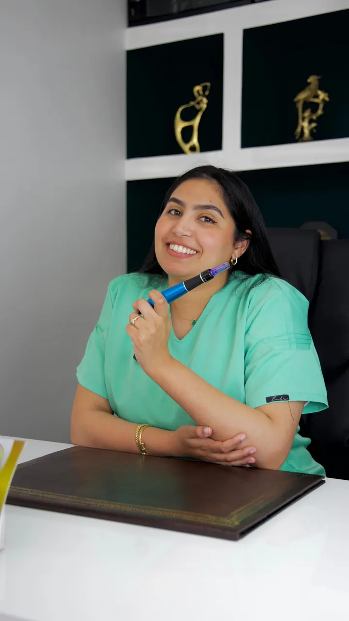 La praticienne tient un stylo de microneedling