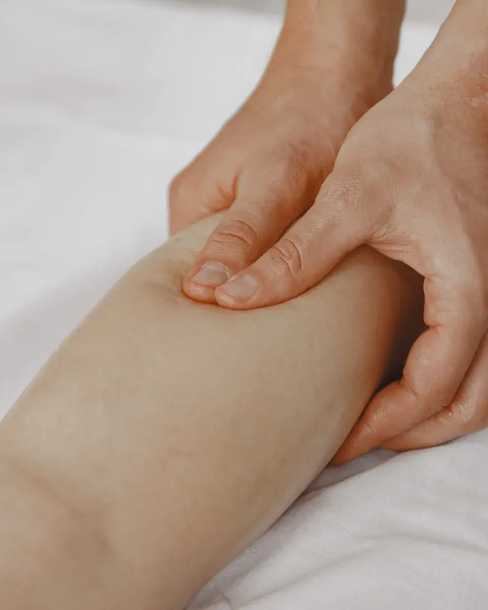 Mains qui pratiquent un drainage sur la jambe