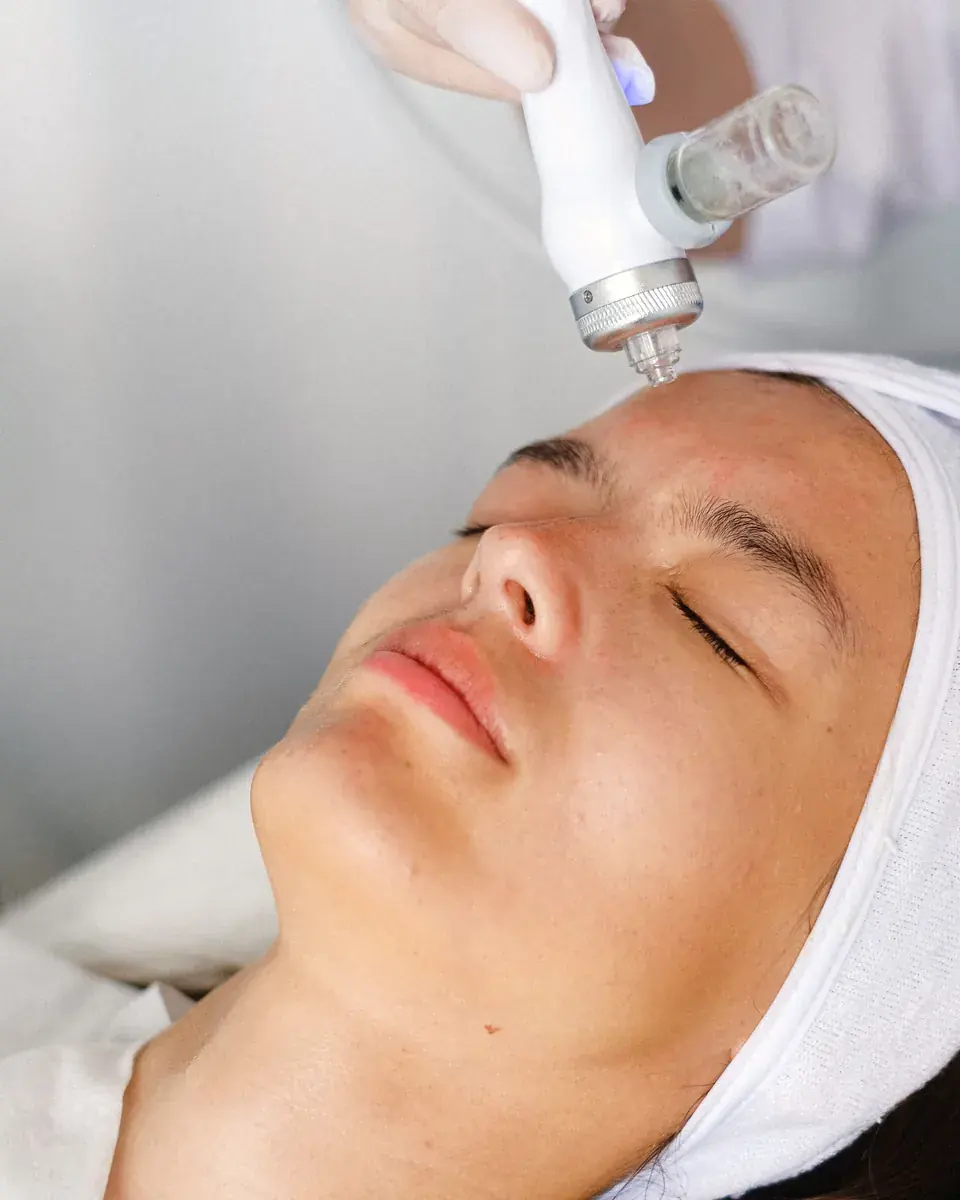 Soin du visage à l'appareil, cliente les yeux fermés