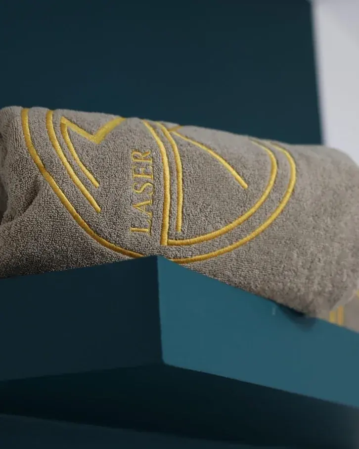 Serviette roulée brodée du monogramme MK Laser